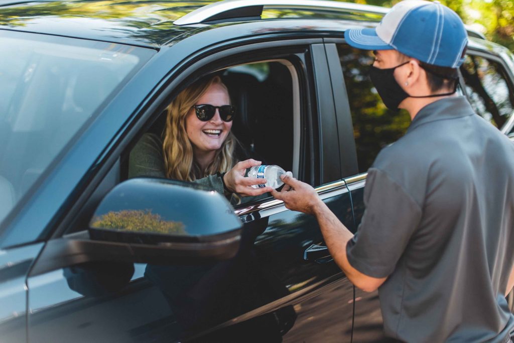 Strickland Brothers employee handing customer a water bottle