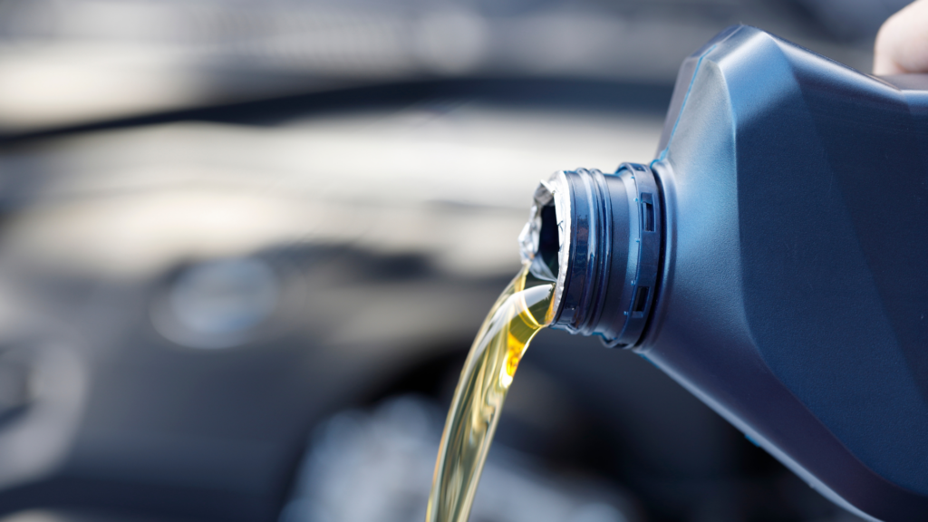 Blue bottle pouring oil into car. How many miles between oil changes? When to change oil?